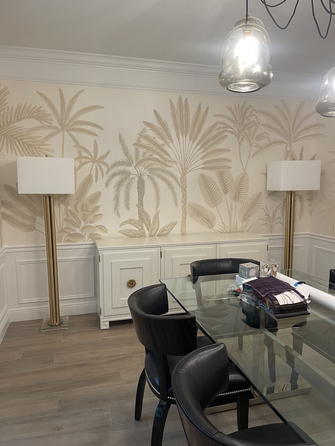 Botanical wallcovering installed by M&C above white paneling in a dining room
